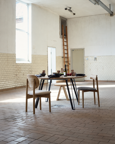Silla de comedor MUUBS junto a una mesa redonda