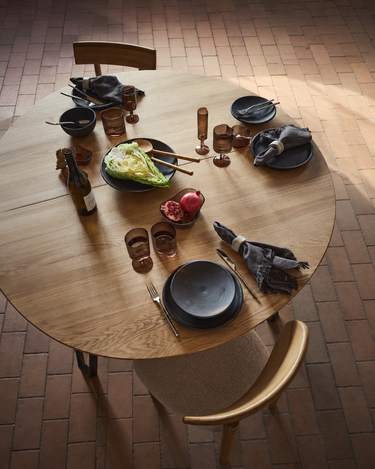 Silla de roble natural alrededor de una mesa preparada para comer