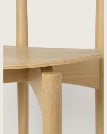 Unión del asiento, la pata y la estructura en una de las sillas Herman de roble natural.