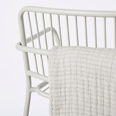 Detalle del respaldo y reposabrazos de la silla beige gris
