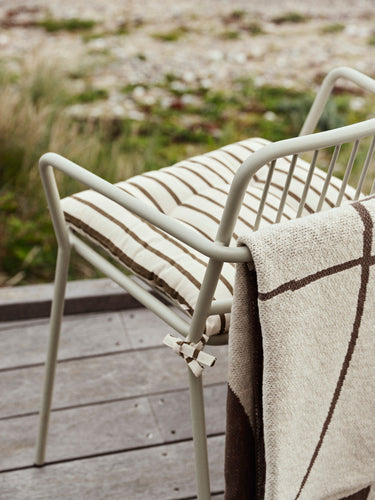 Detalle lateral del asiento y respaldo de la silla beige gris