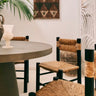 Sillas vintage de madera oscura y fibra trenzada junto a una mesa