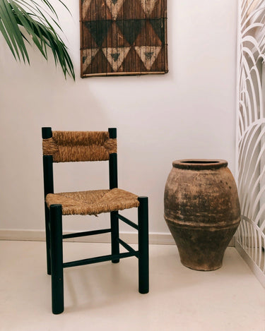 Silla vintage de madera oscura con asiento y respaldo trenzados