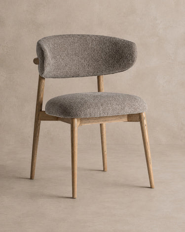 Silla tapizada en topo con madera de arce marrón claro de Vical sobre pared topo claro texturizada