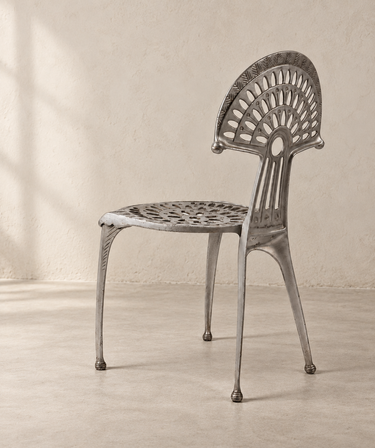 Silla Urogallo de aluminio vintage, vista lateral en habitación de cemento beige