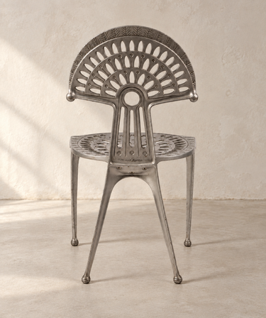 Silla Urogallo Kettal, vista trasera en habitación de cemento beige claro