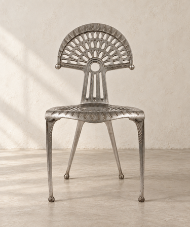Silla Urogallo de Óscar Tusquets para Kettal, vista frontal en habitación de cemento beige