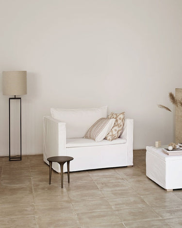 Sillón de Tine K Home en un salón con textiles y tonos naturales