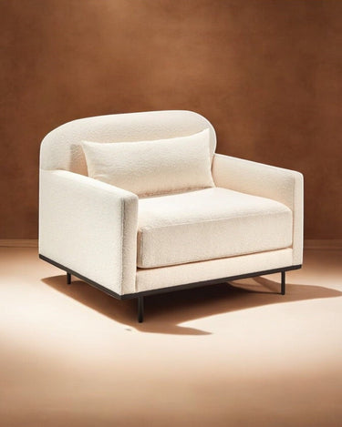 Sillón de bouclé blanco con estructura de madera, junto a la colección de sofás