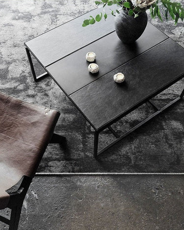 Sillón de cuero junto a una mesa de centro negra en una zona de estar