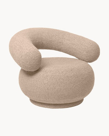Sillón de Ferm Living en bouclé beige claro, visto de tres cuartos.