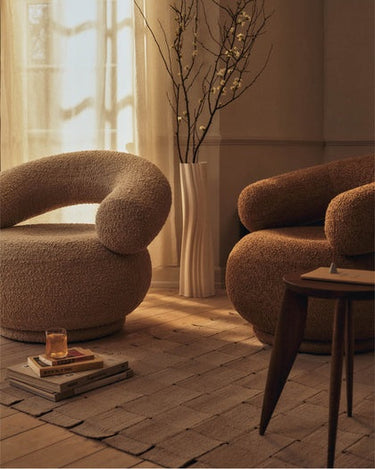Dos sillones Orbo en beige y marrón, colocados en un salón.