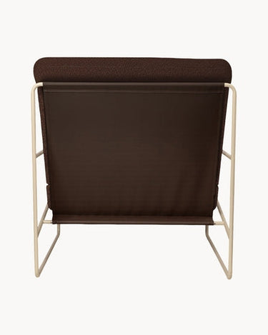 Vista posterior del sillón marrón con estructura beige de acero.