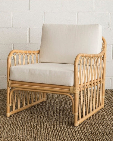 Sillón Knots de ratán natural con cojín de Mahe Homeware, vista en perspectiva con cojines claros
