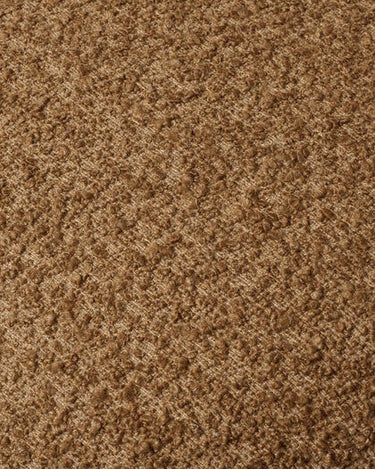 Vista lateral del sillón lounge de bouclé