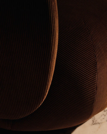 Sillón Rico de terciopelo devoré óxido de Ferm Living, detalle de las curvas bajo la luz