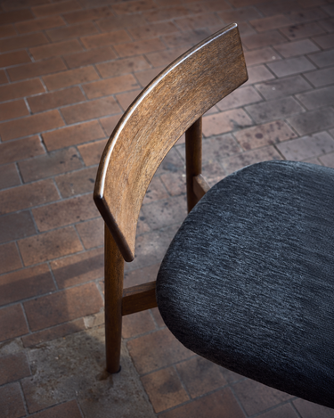 Detalle del respaldo curvo y del asiento tapizado gris