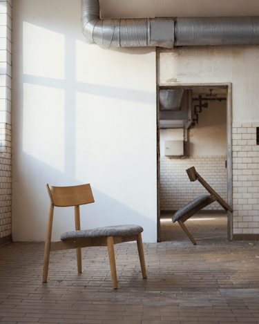 Sillones Tetra en roble natural y oscuro junto a una ventana