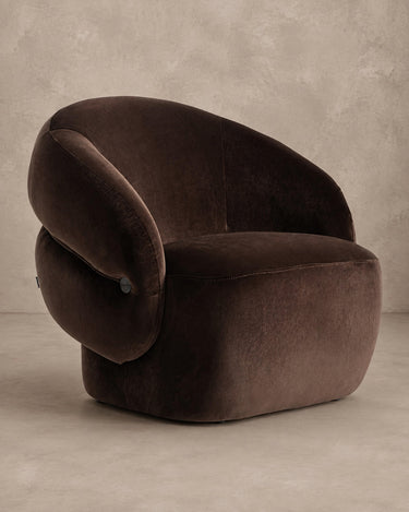 Sillón de terciopelo chocolate y madera de pino de Vical sobre pared topo clara