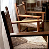 Conjunto de sillones vintage de madera con asiento y respaldo trenzados, detalle junto a una ventana