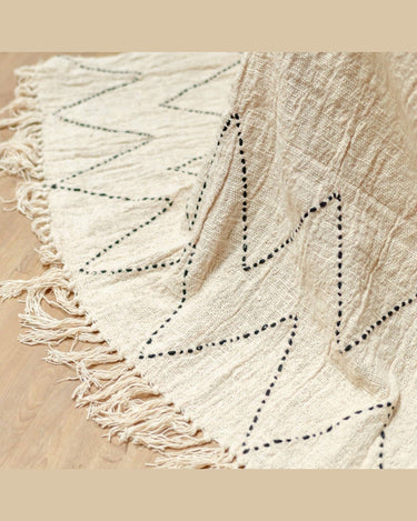 Manta Soeji de algodón blanco crudo con zigzag en sofá natural