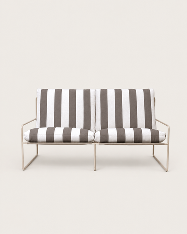 Sofá de jardín de dos plazas con cojines a rayas de Ferm Living: sofá de dos plazas frontal completo, bastidor tubular claro y dos conjuntos de cojines a rayas oscuras y claras.