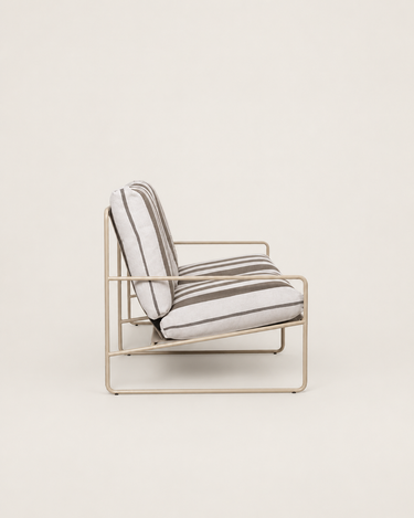 Sofá de Ferm Living: sofá de dos plazas visto desde un extremo en oblicuo; brazo tubular y cojines de asiento y respaldo.