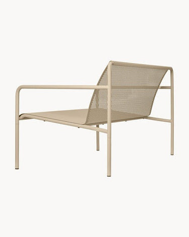 Vista lateral de uno de los sofás Dapple beige, con respaldo inclinado y brazo tubular.
