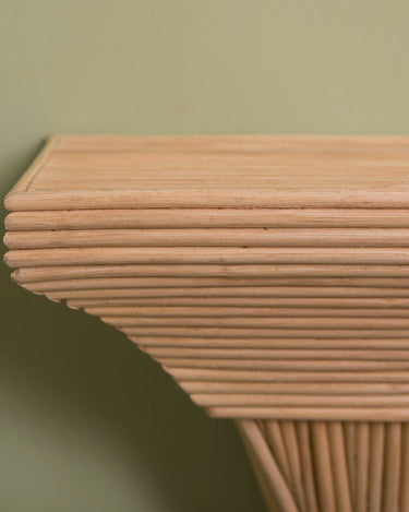 Detalle de la repisa rectangular de Gaia, con franjas de ratán horizontales en el borde