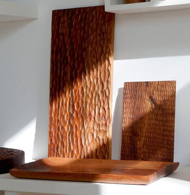 Tabla de servir de nogal tallado biselada de Sangiovanni Lorenzo, junto a otras tablas de nogal