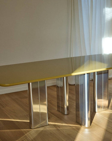 Mesa de comedor Chrysoline lacada ámbar con patas inox brillantes