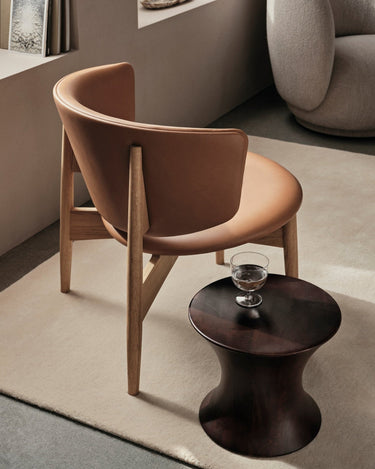 Taburete de madera de mango junto a un sillón