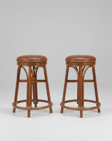 Taburetes vintage de ratán y cuero con estructura natural y asiento marrón