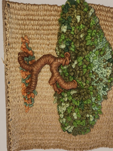 Detalle lateral del árbol de fibras del tapiz, con tronco marrón, copa verde y trama visible