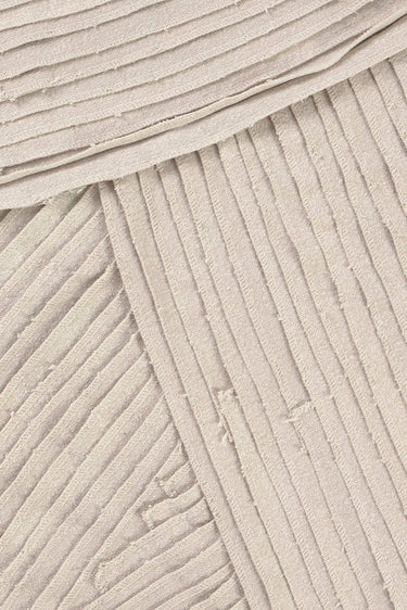 Detalle de los paneles cosidos a mano de un tapiz de lienzo gris