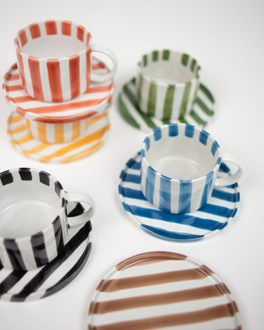 Detail of a hand-painted stoneware cup and saucer by Olsson & Jensen