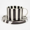Taza con plato a rayas negras y blancas para café