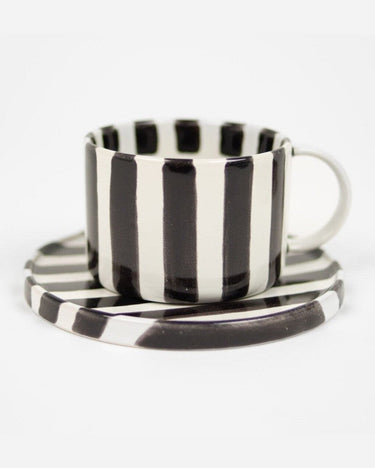 Taza con plato a rayas negras y blancas para café