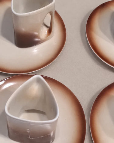 Detalle de las asas y el interior de las tazas vintage beige y marrón