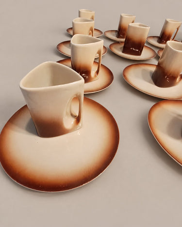 Varias tazas vintage con asas curvas y esmalte beige y marrón