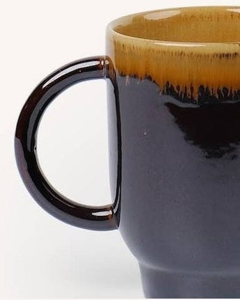 Detalle de set de dos tazas de cerámica marrón flameada mostrando su textura