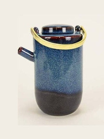 Vista superior de tetera de cerámica esmaltada con asa de latón negro y sus proporciones