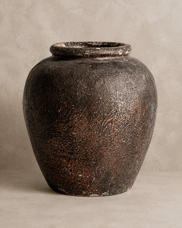 Tinaja Vical de terracota marrón sobre fondo topo claro texturizado