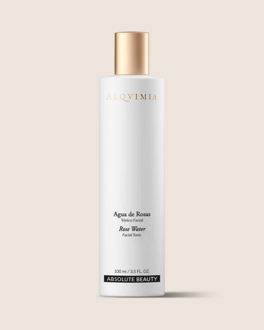 Tónico facial de rosas de ALQVIMIA: frasco blanco con tapón dorado, sobre fondo beige.