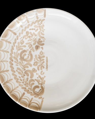 Plato de postre con decoración beige en media superficie.