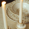 Vajilla de gres con arcos pintados en beige de Leandro Cano: vajilla pintada beige con candelabros y velas en primer plano.