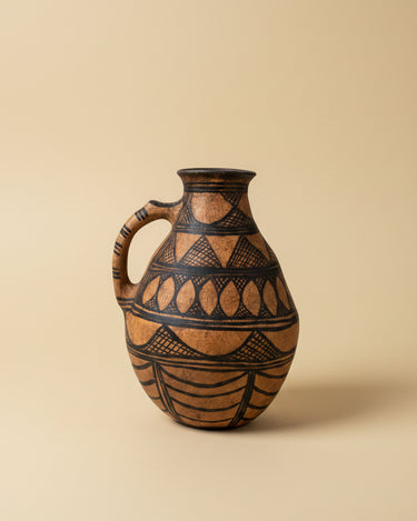 Vasija vintage de terracota con motivos geométricos negros