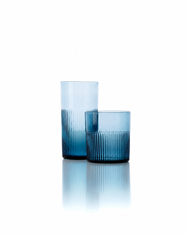 Vaso alto de vidrio azul ondulado, junto a un vaso bajo de vidrio azul ondulado