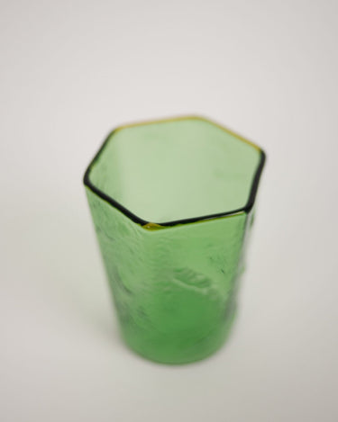 Vista cercana del vaso Nola verde con borde facetado y superficie texturada de Olsson & Jensen
