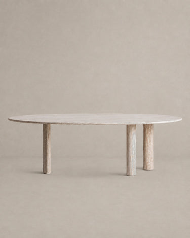 Mesa de comedor de travertino blanco roto de Vical sobre pared y suelo topo claro